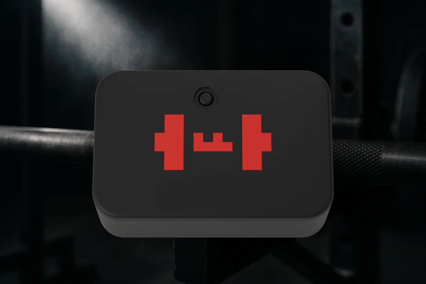 The TEMPO ANVIL from above, on a barbell: the black puck with its red mark and the small round button set into the lid